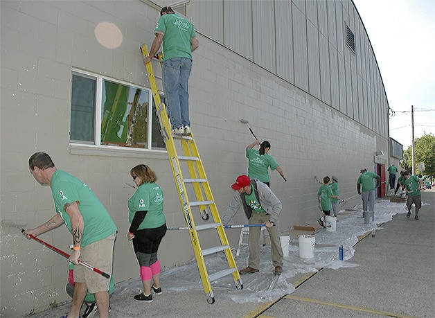 Dozens of the hundreds of Comcast volunteers combined to quickly paint the outside of the Marysville Boys and Girls Club.