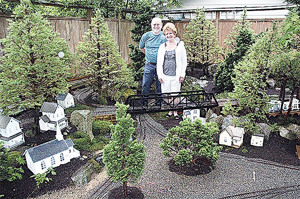 Mike and Janet Elmore's back yard in Marysville is perfectly landscaped with a railroad track and villages all around. They will open up their home to visitors Aug. 2 as a fund-raiser for the food bank.