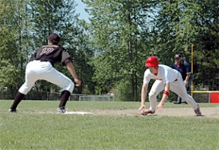 Tomahawk senior Levi Cartas dives for the safety of first base. Getting the base on a walk in the seventh inning
