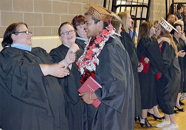 Students and faculty at Tulalip Heritage High School exchange congratulatory hugs at the graduation ceremony in the gym June 11.