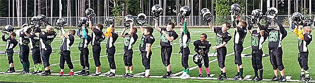 Members of the Pee Wee football team Chargers salute teammate Kennedy O'Day