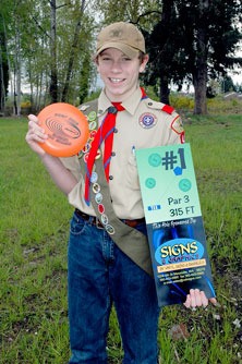 Christian Hauer shows off an example of one of the sponsorship signs through which he hopes to raise the remaining funds for a flying disc golf course near the Strawberry Fields for Rover off-leash dog park.