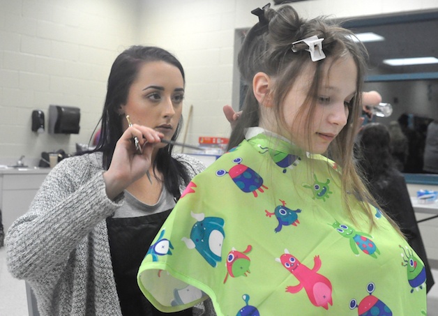 Danielle Dobler trims the hair of Samantha Christiansen at the Marysville Family YMCA Jan. 24.