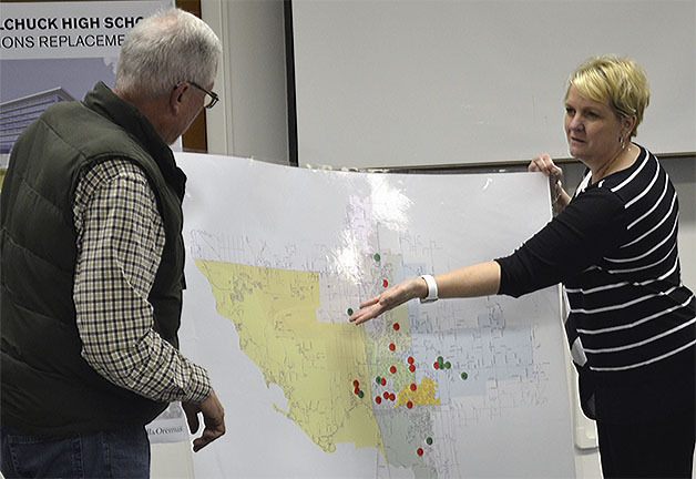 School Board President Pete Lundberg and Superintendent Becky Berg look at a map showing the location of schools in the district.