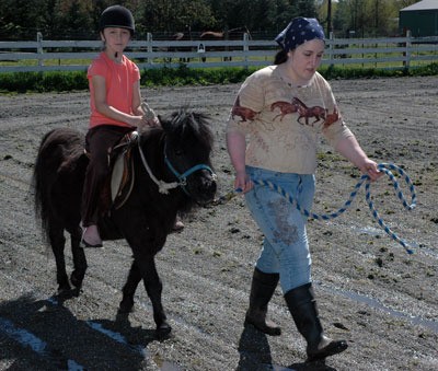 Amelia Myers is led on a pony ride on ‘Blacky’ by All Breed Equine Rez-Q volunteer Becky Segault April 21.