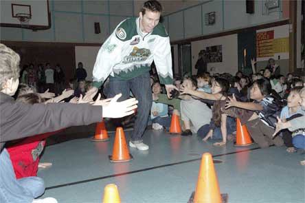 Everett Silvertips player Paul Sohor gives students low-fives as he enters the Kellogg Marsh Elementary gymnasium Dec. 17.