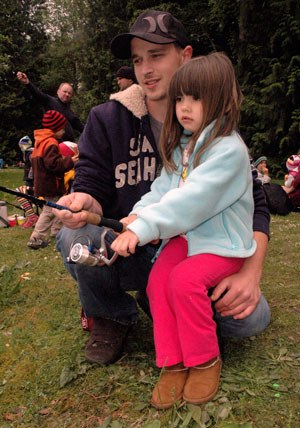 Arlington’s Joey Baker helps his 3-year-old daughter Addison out with her rod and reel at the May 18 kids’ fishing event at Twin Lakes County Park.