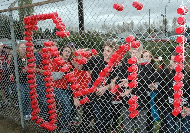 Marysville-Pilchuck High School students use red plastic cups to form the words 'MP STRONG' in the chain-link fence around Quil Ceda Stadium Nov. 3.