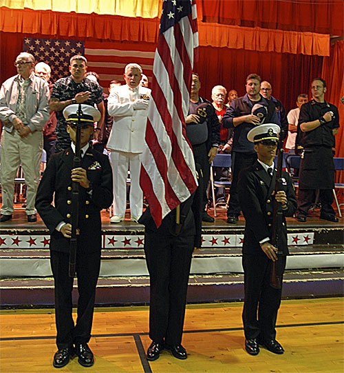 Honored veterans stand up for the U.S. flag in a ceremony Monday at Cascade Elementary School in Marysville.
