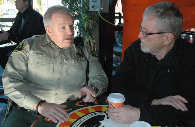 Snohomish County Sheriff Ty Trenary speaks with Arnie Aljets and other area residents at Vinacio Coffee in Marysville on Feb. 5.