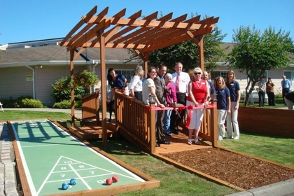 Marysville City Council members Carmen Rasmussen and Donna Wright steady the ribbon for Mayor Jon Nehring to cut Aug. 25