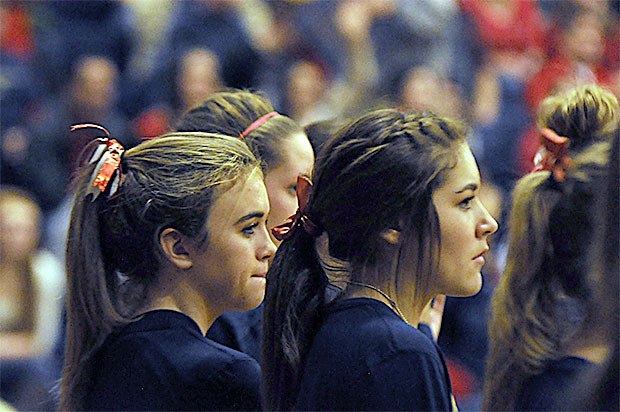 Arlington volleyball players wear red bows in their hair in a show of support as they played Marysville Pilchuck Wednesday night.