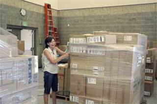 Grove secretary Marylou Oas was among the many staffers charged with helping unwrap and place the hundreds of boxes of equipment and supplies that had the new school’s gym resembling a crowded warehouse.