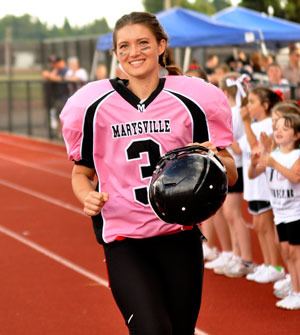 Jennifer Marsh is cheered on by the crowd as she takes the field in the annual Powder Puff Football game on June 28.