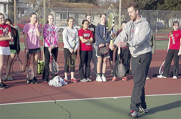 M-P coach Evan Shaw shows the girls tennis team how to punch at the ball when volleying at the net