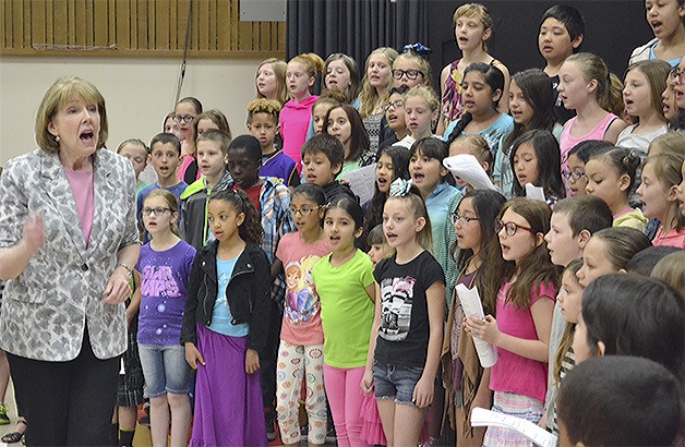 Music teacher Brenda Earhardt directs the 100-member choir at Sunnyside Elementary School in Marysville. Sixty of the members get to perform the 'Star-Spangled Banner' at a Mariners game.