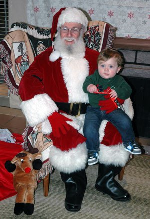 Santa Claus keeps a contented Kyle Paquette on his lap for the boy’s first Christmas.