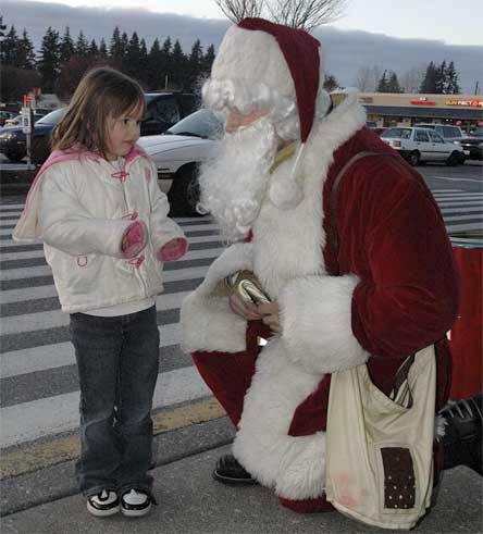 Madison Walton speaks with Santa Claus while the Marysville Fire District Foundation collects for the Marysville Community Food Bank Dec. 11.