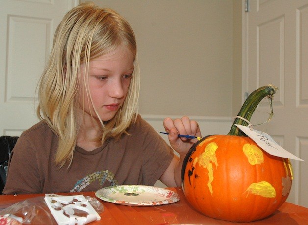 Piper Staley paints a pumpkin at Schaefer-Shipman's Harvest Festival Oct. 4.