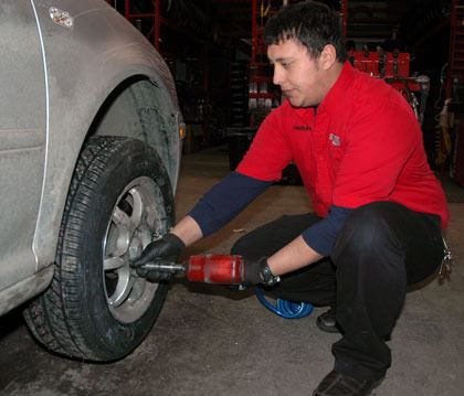 Lakewood Discount Tires employee Tristan Fager prepares to remove an all-season tire and replace it with a winter tire Nov. 26.