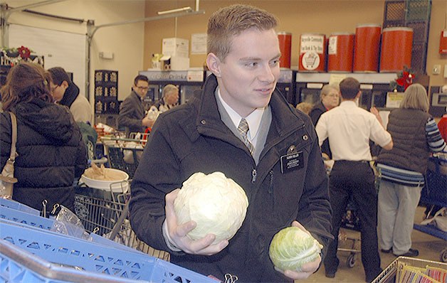 Volunteer Brandon Fuller helps out a client at the Marysville Food Bank.