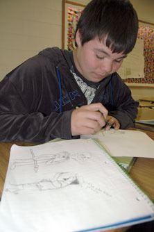 Totem Middle School eighth-grader Miguel Mathis works on his political cartoon