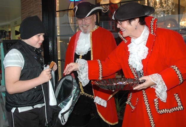 Trick-or-treater Mickey Wolff receives some candy from kindly pirates Dana and Lorene Wren