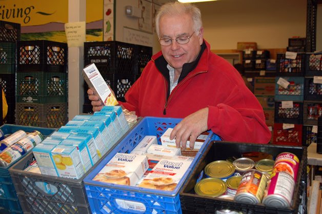 Marysville Community Food Bank volunteer Terry Earnheart sorts canned goods and mixes on Dec. 20.