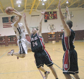 Michael Leach attempts to shoot over the Nathan Hale defenders. Leach eventually fouled out