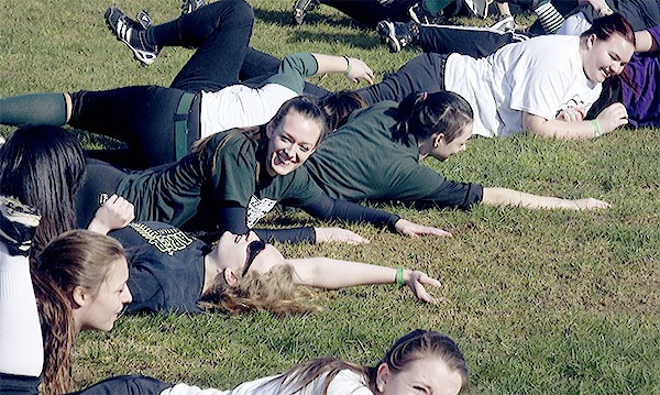 Marysville Getchell girls softball team players are all smiles after pretending to dive back to first base during practice March 3.