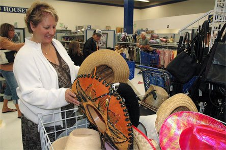 Karen Miller examines cowboy hats at the Marysville Goodwill Aug. 14