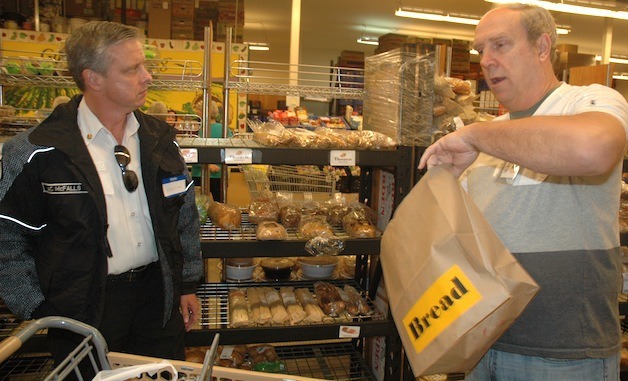 Marysville Fire Chief Martin McFalls is guided through the Marysville Community Food Bank's shopping line by volunteer Mark Poplar.