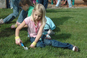 Eight-year-old Madelyn Teerlink of Marysville shovels weeds out of the grass at Jennings Nature Park on Saturday