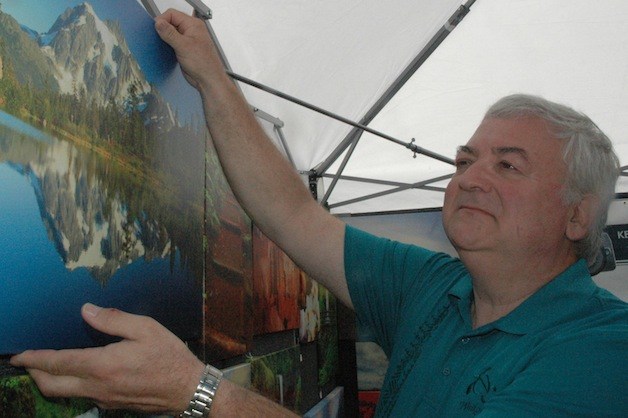 Marysville's Kenneth Fritts adjusts a canvas reproduction of his photo of Picture Lake at Mount Shuksan Aug. 10.