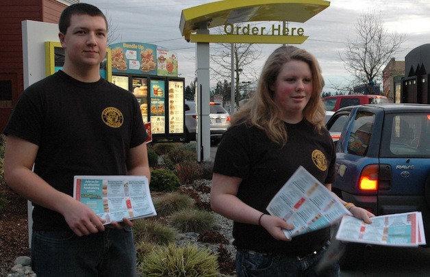 Nathen Flynn and Eleanor Wilde hand out coupon sheets at the McDonald’s.