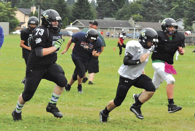 Members of the Marysville Youth Football Association’s Junior Black Chargers get warmed up during practice on Thursday