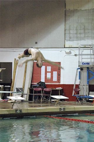 Senior diver Taylor Gibson prepares for a hands-first entrance into the pool. Gibson won the meter dive against Cascade