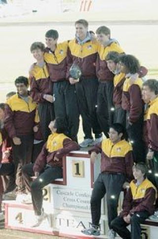 The Lakewood boys cross country team poses atop the awards podium after running to a victorious first-place finish Saturday