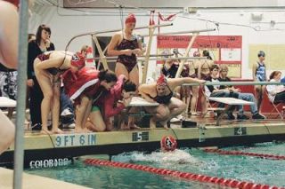 Teammates cheer on Julia Turner near the starting block as Turner competes in the 200 individual medley.