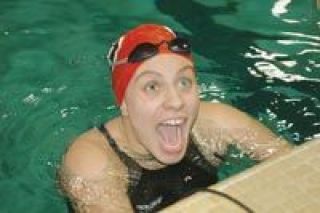 Sophomore Kami Girard is all smiles after seeing her new school record time in the 100-yard backstroke Saturday