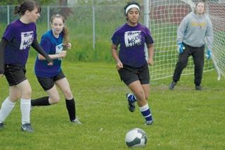 Loveleen Kaler depends on her teammate to block opponent Ashleigh Ginder during evening matches near Strawberry Fields in Marysville.