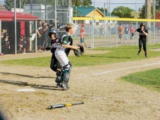 Walker Coffee Companys Beau Wells runs into home with teammate Tyler Summers not far behind. Their runs were part of a nine-run rally that gave Walker Coffee the win over the South Snohomish As.