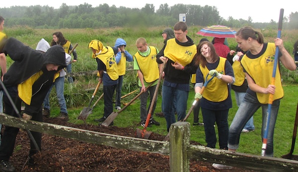 More than 100 youth from the Church of Jesus Christ of Latter-day Saints work to create a walking path to the Strawberry Fields Off-Leash Dog Park on June 23.
