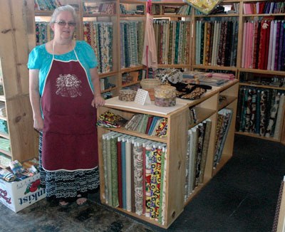 Loving Stitches Quilt Shop owner Bonnie Wenberg shows off some of the roughly 3