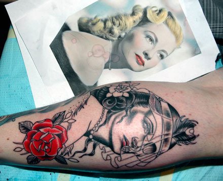 A photo reference is used for a tattoo being applied to the calf of Marysville resident Levi Bissitt’s right leg