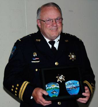 Larry Groom shows off his uniform patches from the Tulalip Police Department during his Aug. 26 retirement from law enforcement.