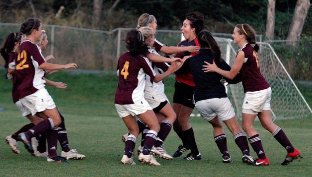 Lakewood girls soccer players surround goalkeeper Miranda Head after defeating Archbishop Murphy in a shootout for the first time in 2010 - and in school history.