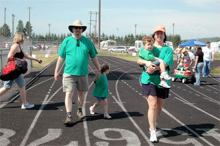 Matt and Sue McGourty walked around the track at Relay for Life June 13 at Marysville-Pilchuck High School as a family. Matt holds the hand of his daughter