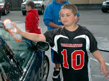 Nathaniel Anderson scrubs cars clean at Gold’s Gym on State Avenue on Aug. 13