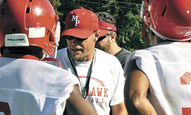 Tomahawks’ head coach Brandon Carson instructs varsity defensive players on the first day of practice